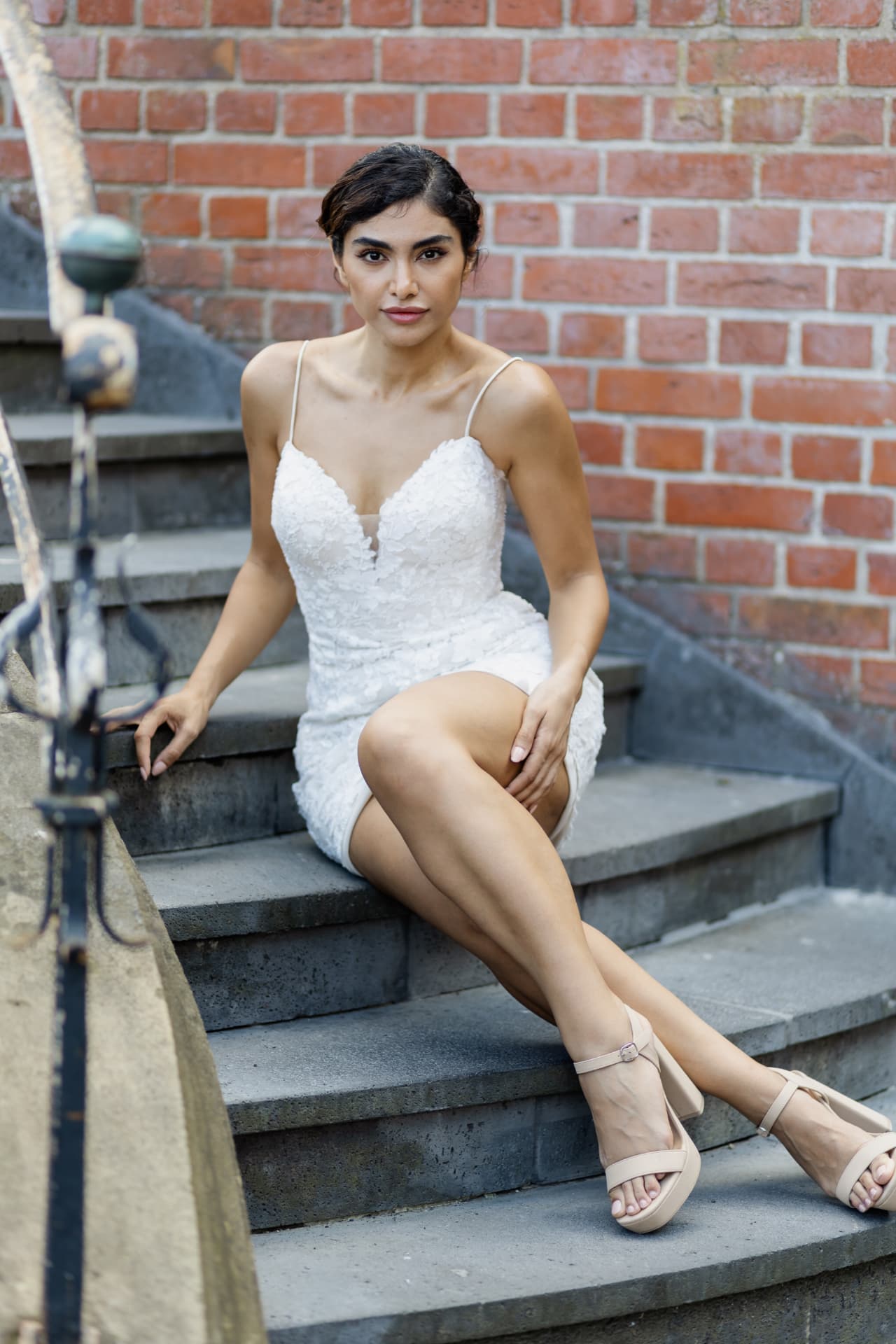 Femy Malekian in weißem Kleid auf einer Treppe